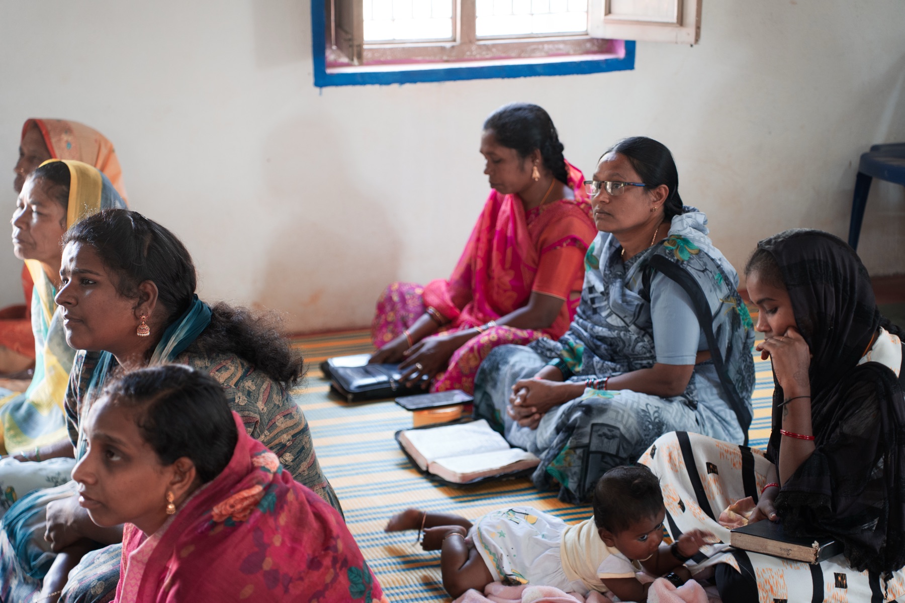 Women and children gathered on the floor for a church Bible study